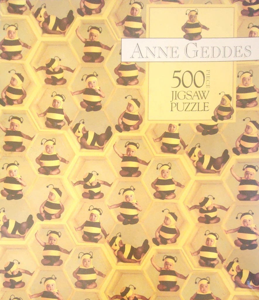A pattern of babies dressed in bumblebee costumes, each inside a honeycomb-shaped cell.