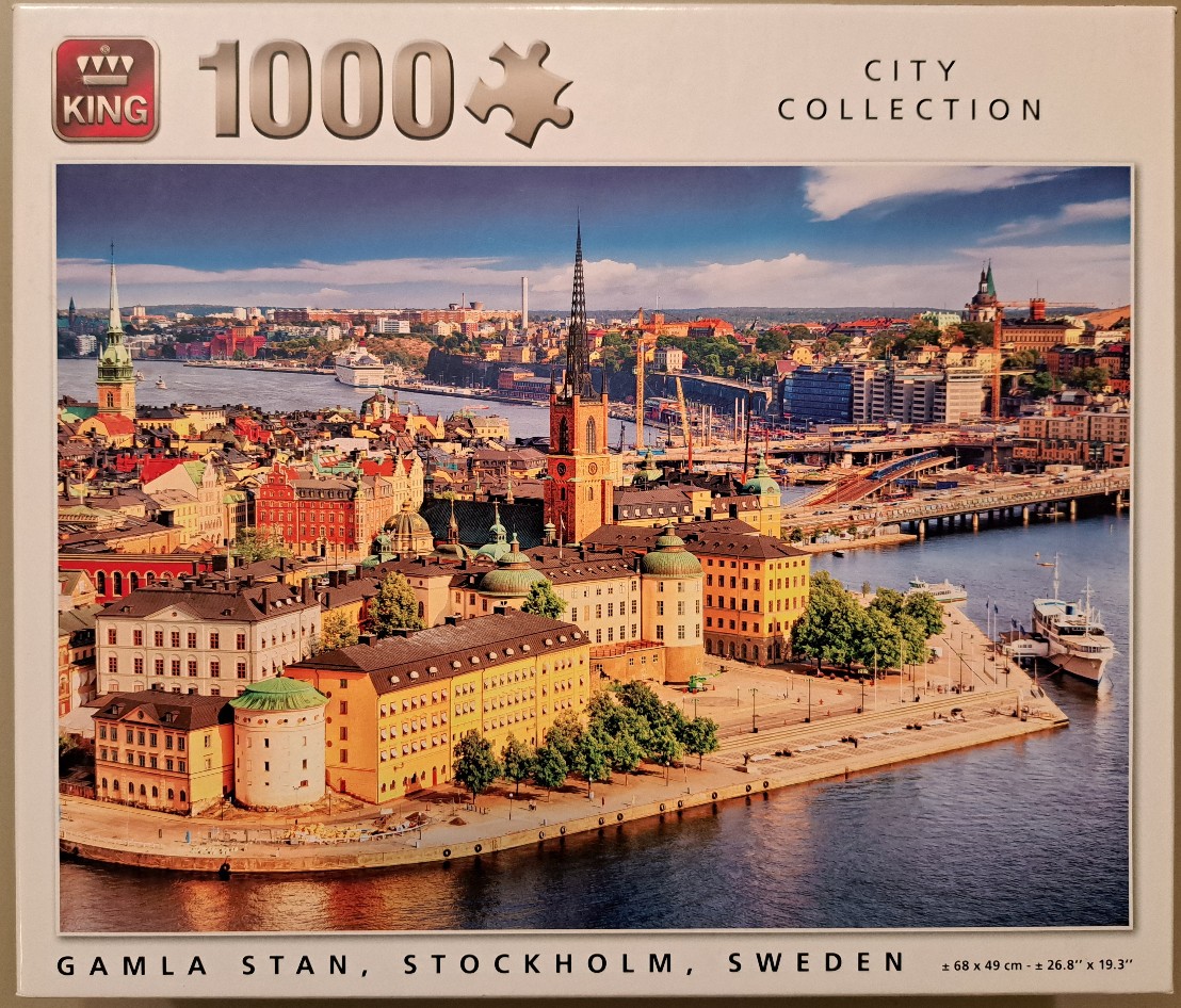 A panoramic photograph of Gamla Stan, Stockholm, featuring historical buildings, a tall church spire, and waterfront.