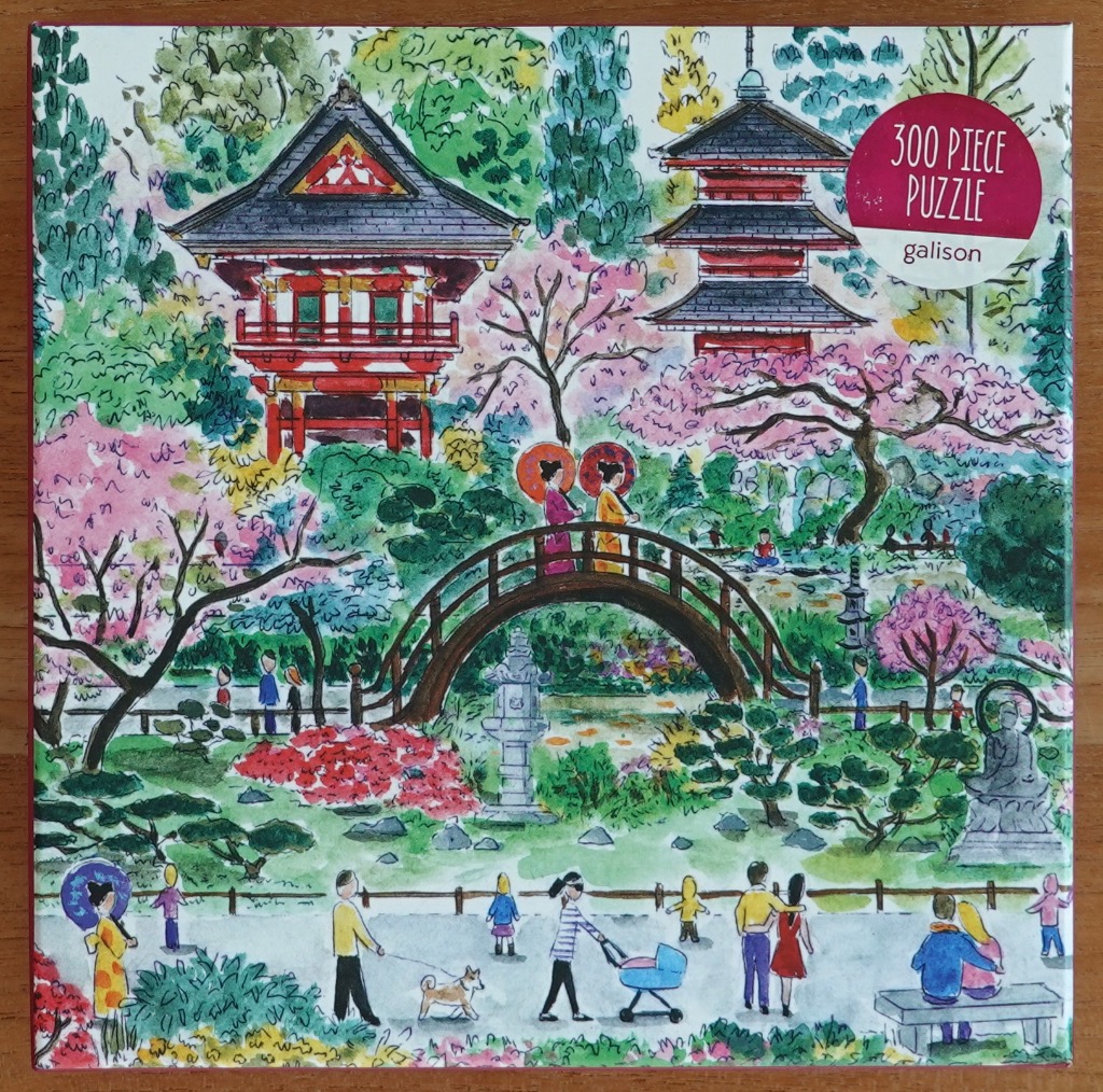 Watercolor illustration of a bustling Japanese-style garden with a pagoda, arched bridge, and visitors.