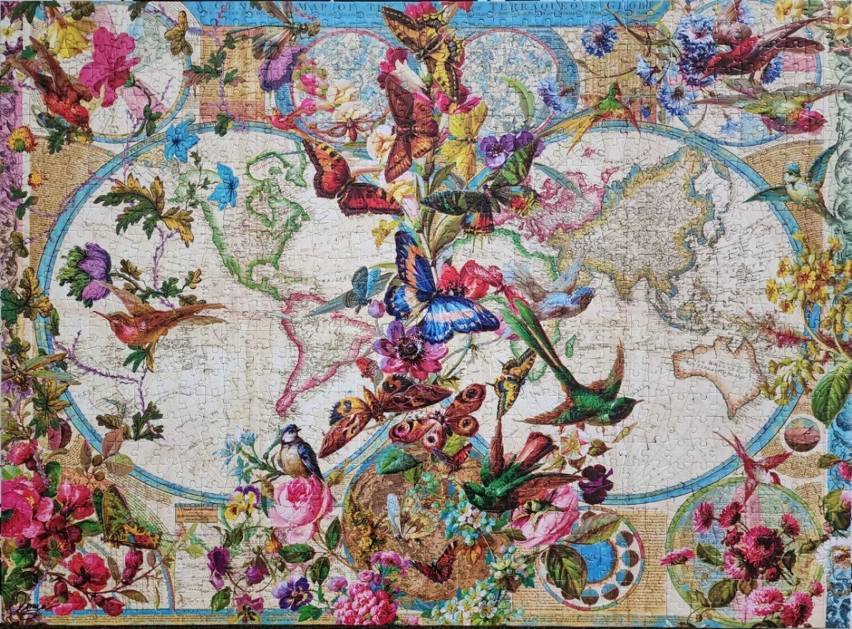 An antique-style world map decorated with vibrant butterflies, hummingbirds, and blooming flowers.