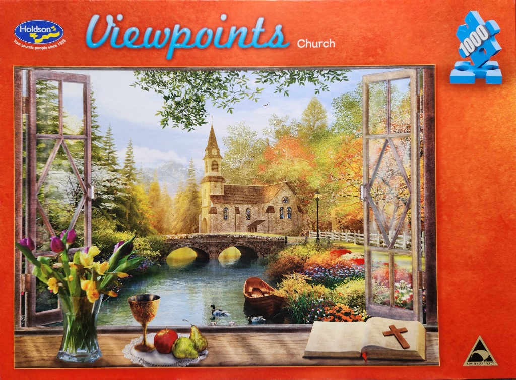 View from a window of a stone church by a stream with a vase of tulips, fruit, and an open Bible on the windowsill.