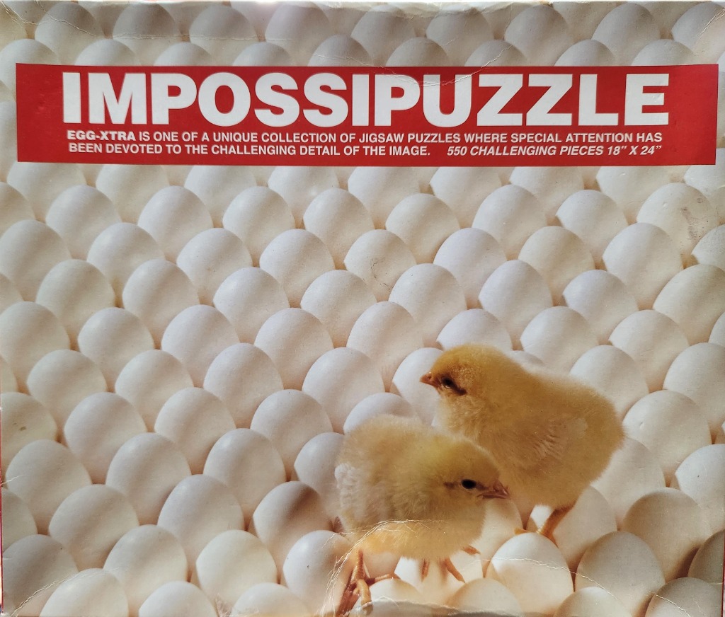 Two yellow chicks standing on a background of uniform white eggs.