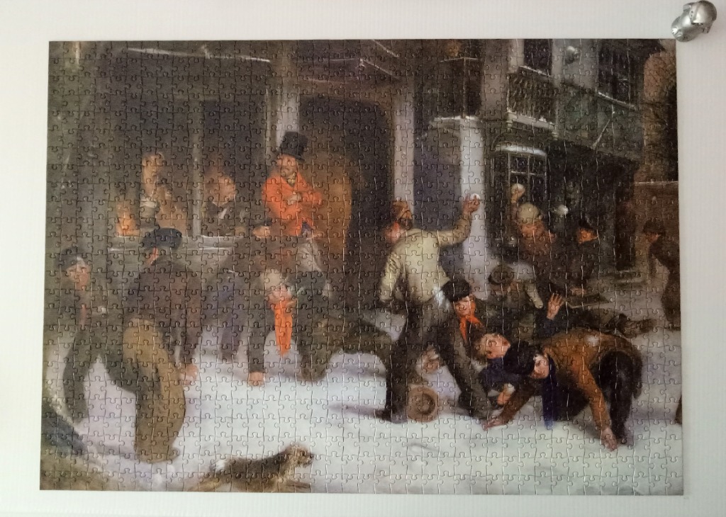A lively group of children and adults engaged in a snowball fight in a snow-covered village street.