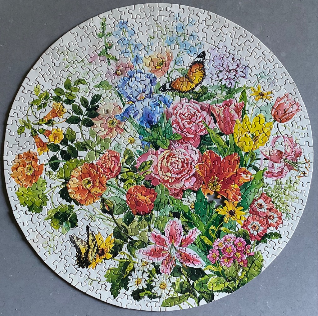 A circular illustration of a lush garden bouquet featuring vibrant pink roses, lilies, and two colorful butterflies.