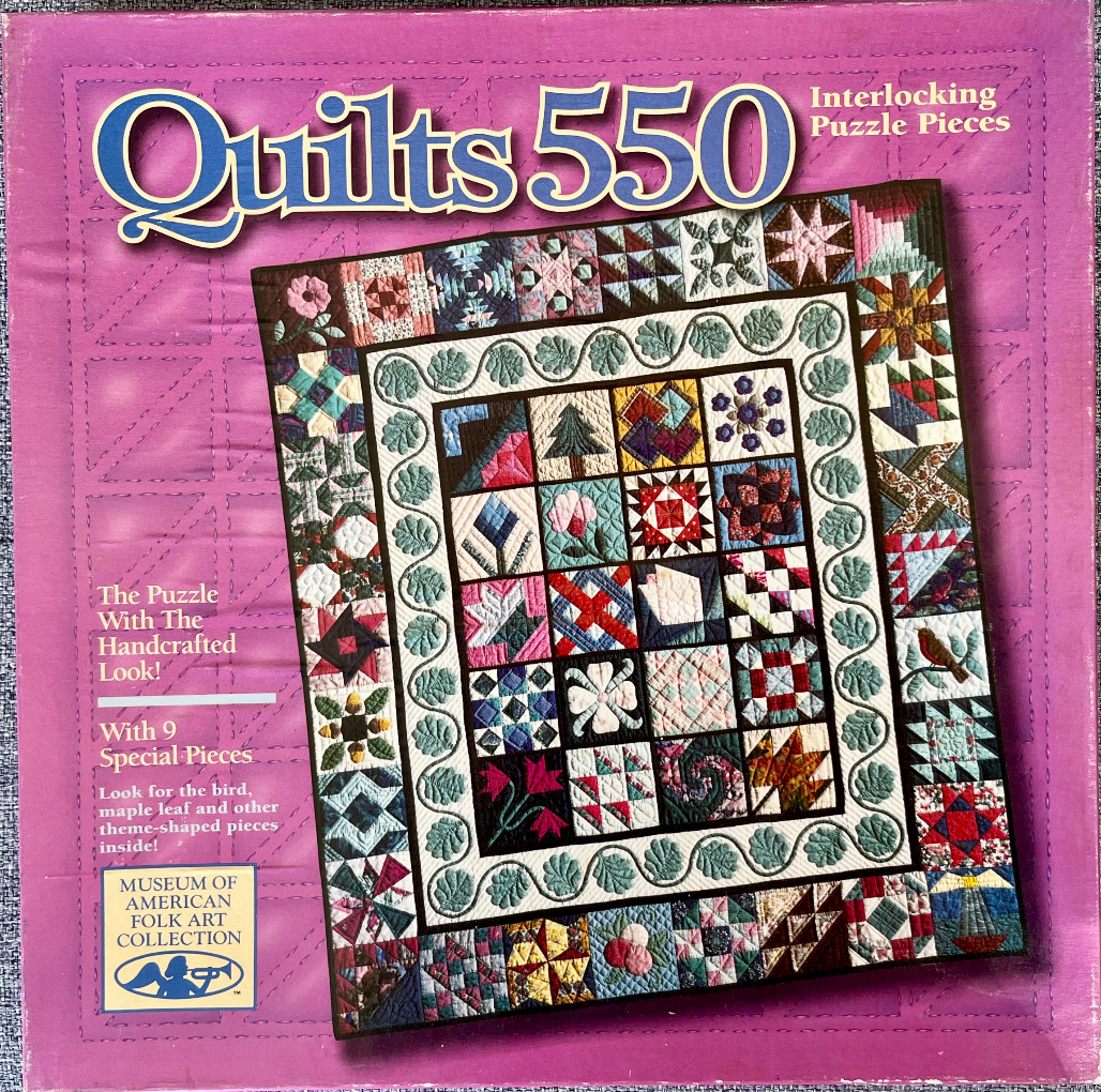 A square patchwork quilt featuring a grid of diverse geometric and folk-art style quilt blocks surrounded by a border.