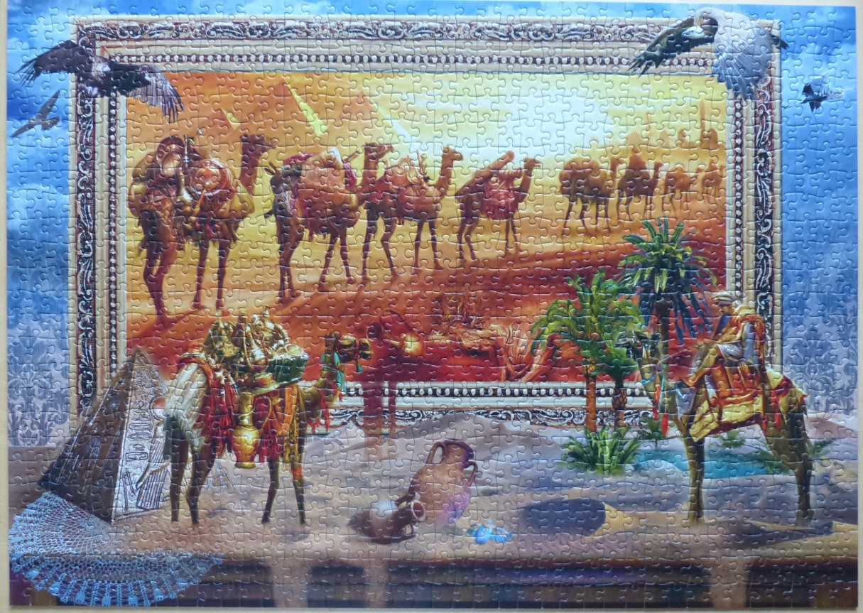 A framed desert scene depicting a camel caravan with pyramids and an Egyptian-inspired foreground.