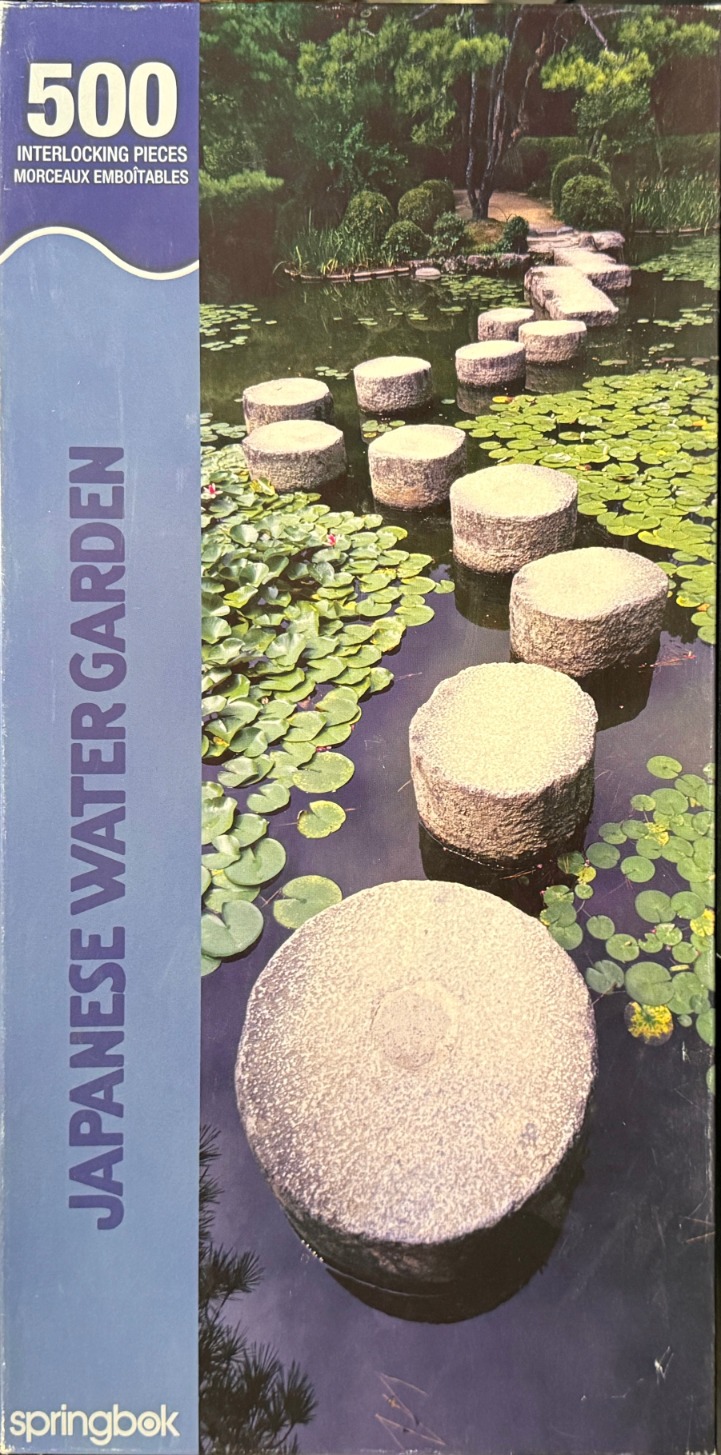 A photograph of stone stepping stones crossing a pond with lily pads in a Japanese garden.