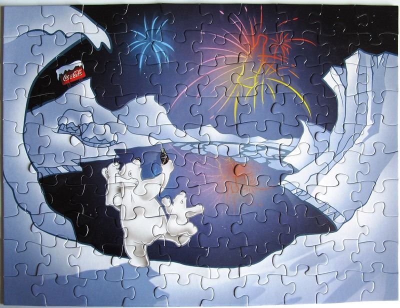 Polar bears watching fireworks over a snowy landscape with a branded sign in the distance.