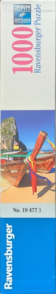 Thailand longtail boats on a beach with a limestone cliff and blue sky.
