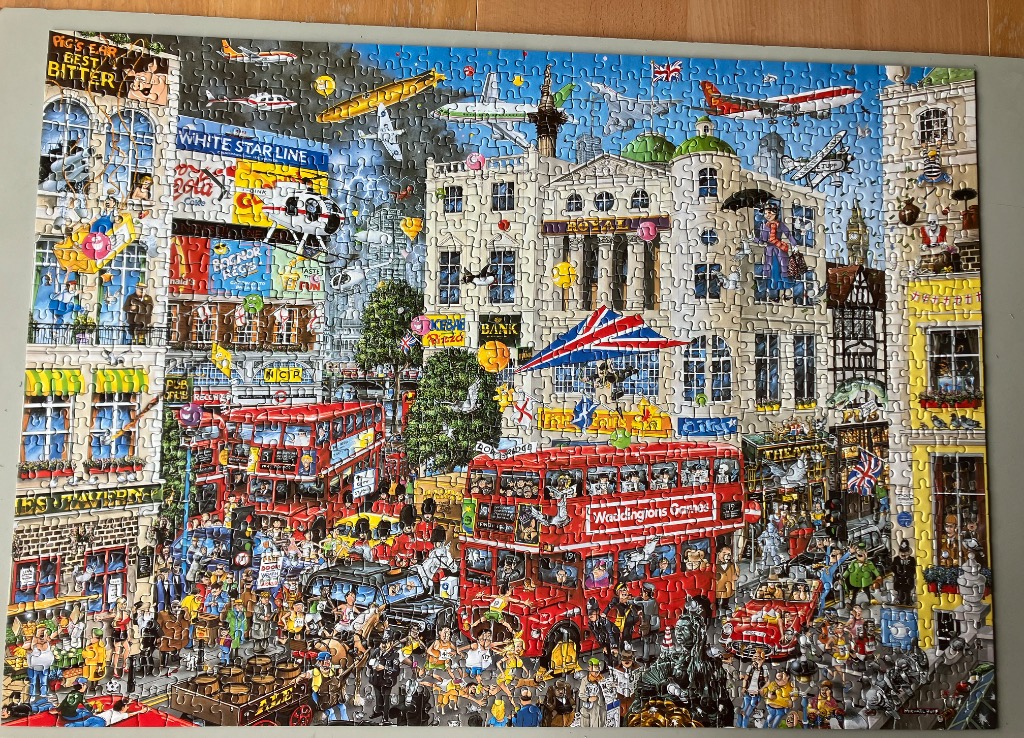 A chaotic, humorous illustration of a busy British city street filled with red double-decker buses and pedestrians.