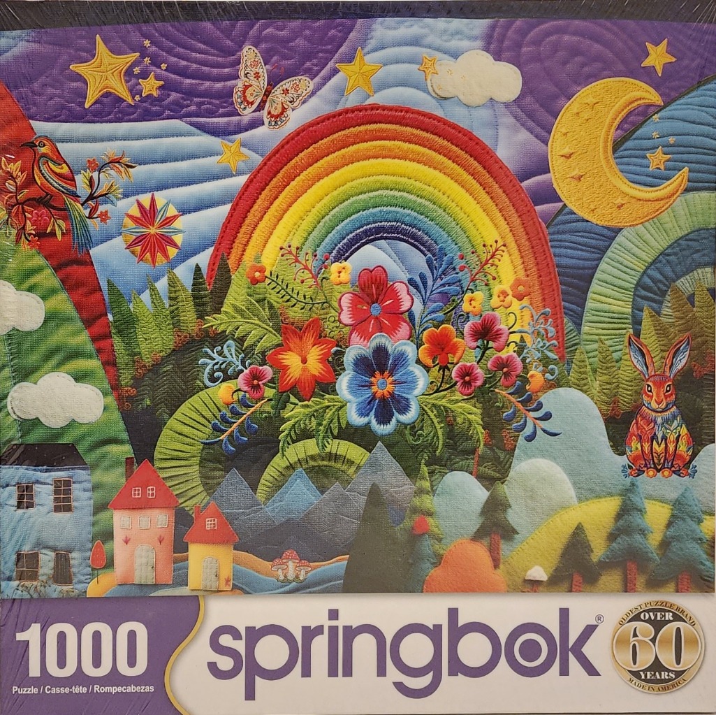 A vibrant fabric-art style illustration featuring a rainbow, flowers, a rabbit, and a whimsical landscape.