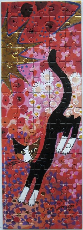 A whimsical vertical painting of a calico and black cat stretching amidst a stylized field of red, pink, and gold flowers.