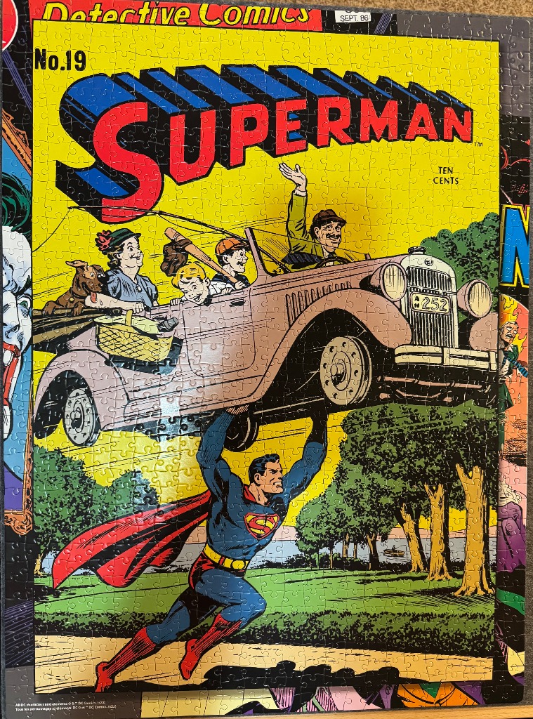 A vintage Superman comic book cover featuring the hero lifting a car full of people.
