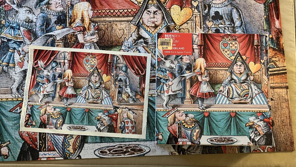 Illustration of Alice standing before the Queen of Hearts in a courtroom scene with playing card characters.
