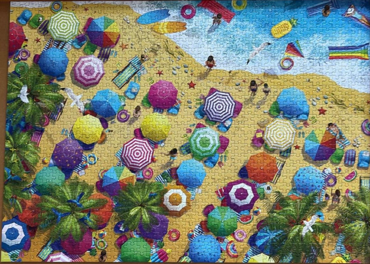 An overhead, bird's-eye view illustration of a crowded, colorful beach filled with umbrellas and beachgoers.