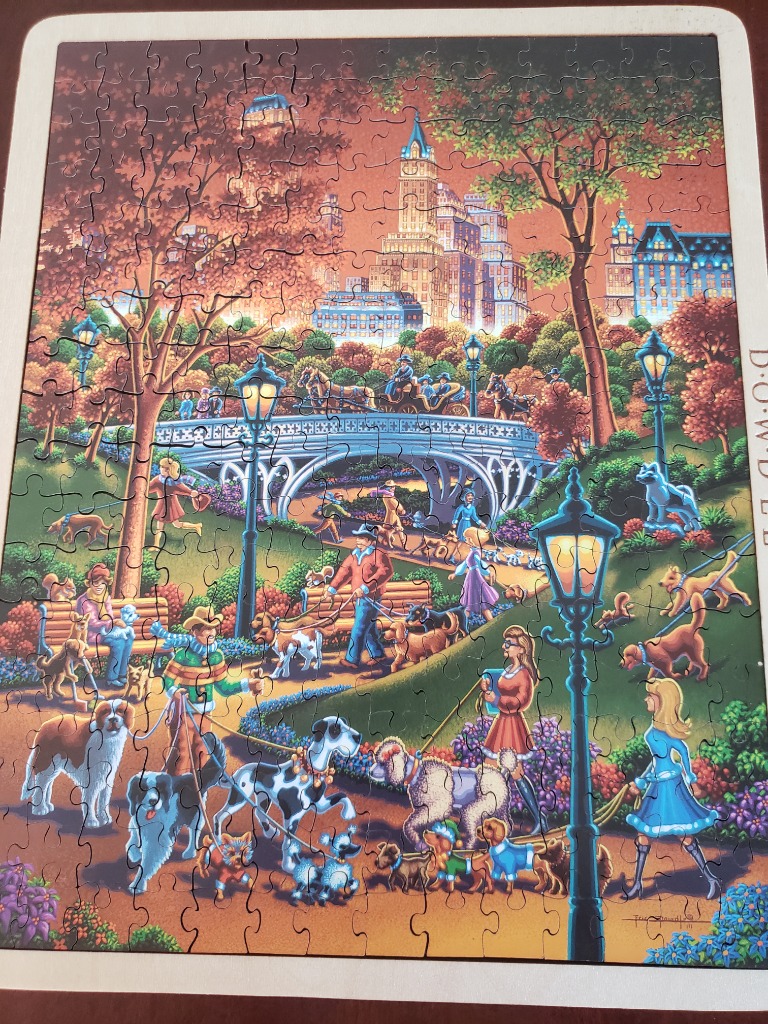 A whimsical illustration of a busy, dog-filled park in autumn with a city skyline in the background.