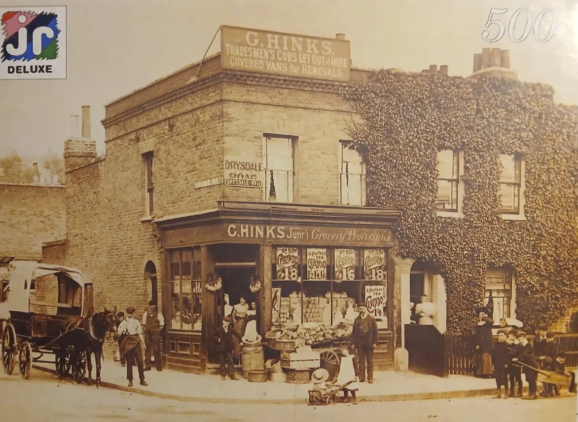 A vintage sepia photograph showing a bustling G. Hinks grocery store corner with a horse-drawn carriage.