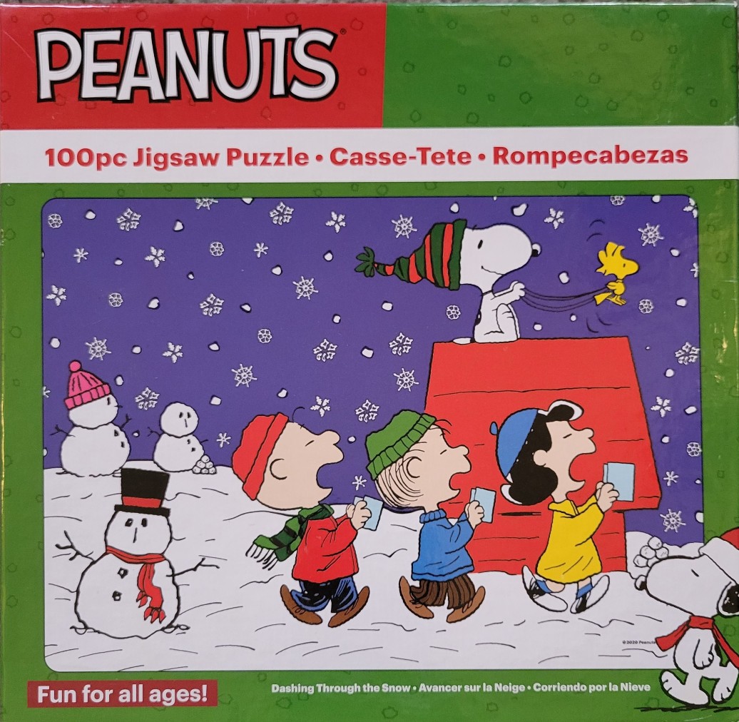 Peanuts characters caroling in the snow with Snoopy, Woodstock, and snowmen.