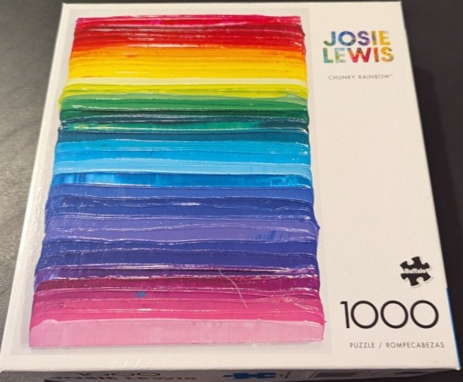 Abstract art of thick, glossy horizontal rainbow-colored paint stripes on a white background.