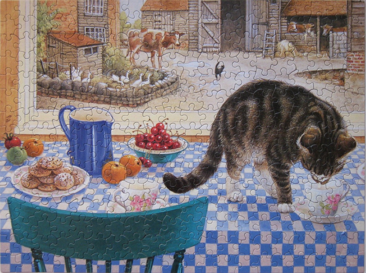 A tabby cat on a kitchen table with farm animals visible through the window.