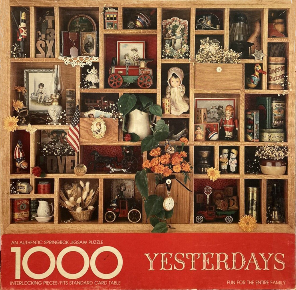 A collection of vintage toys, trinkets, and memorabilia arranged in a wooden printer's drawer.