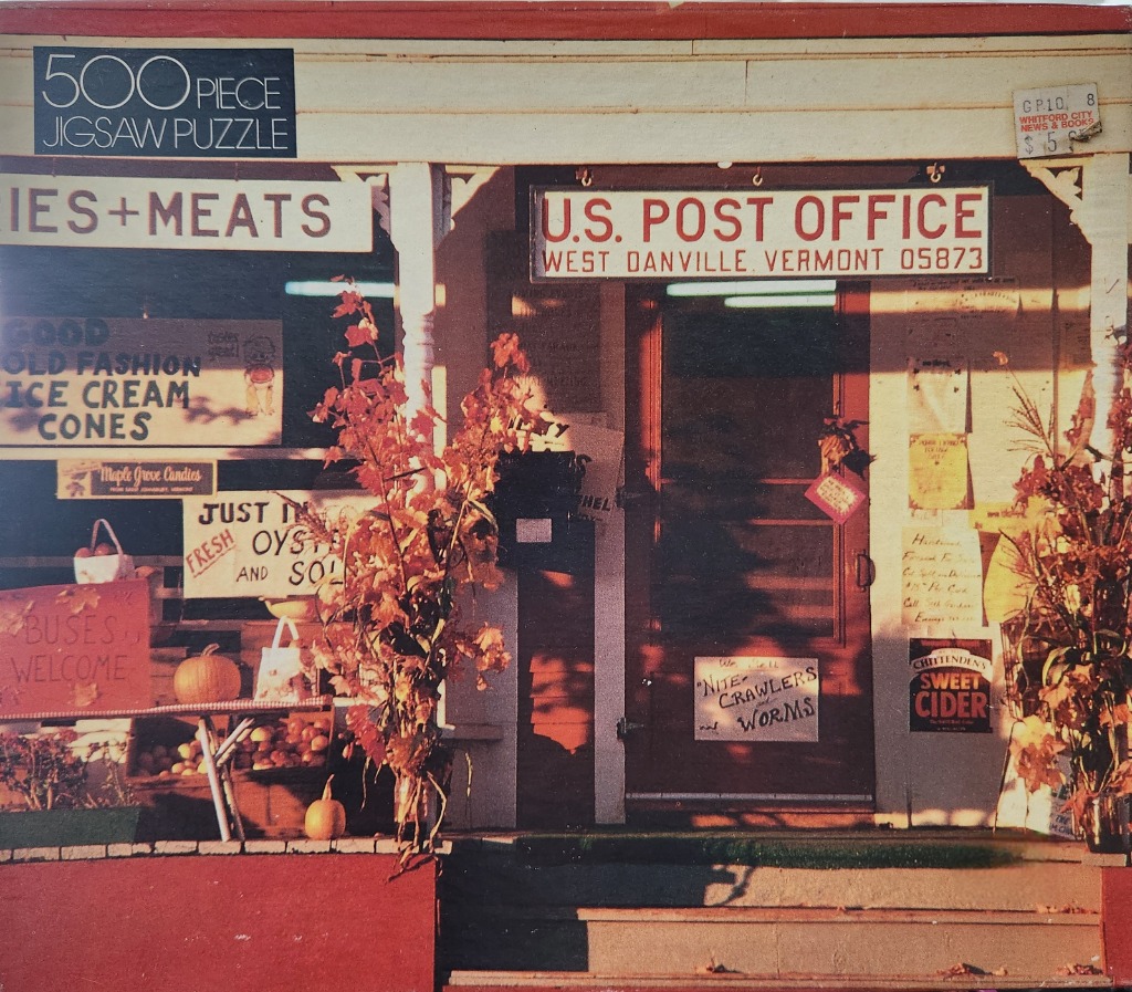 A photograph of a small country general store and post office decorated for autumn.
