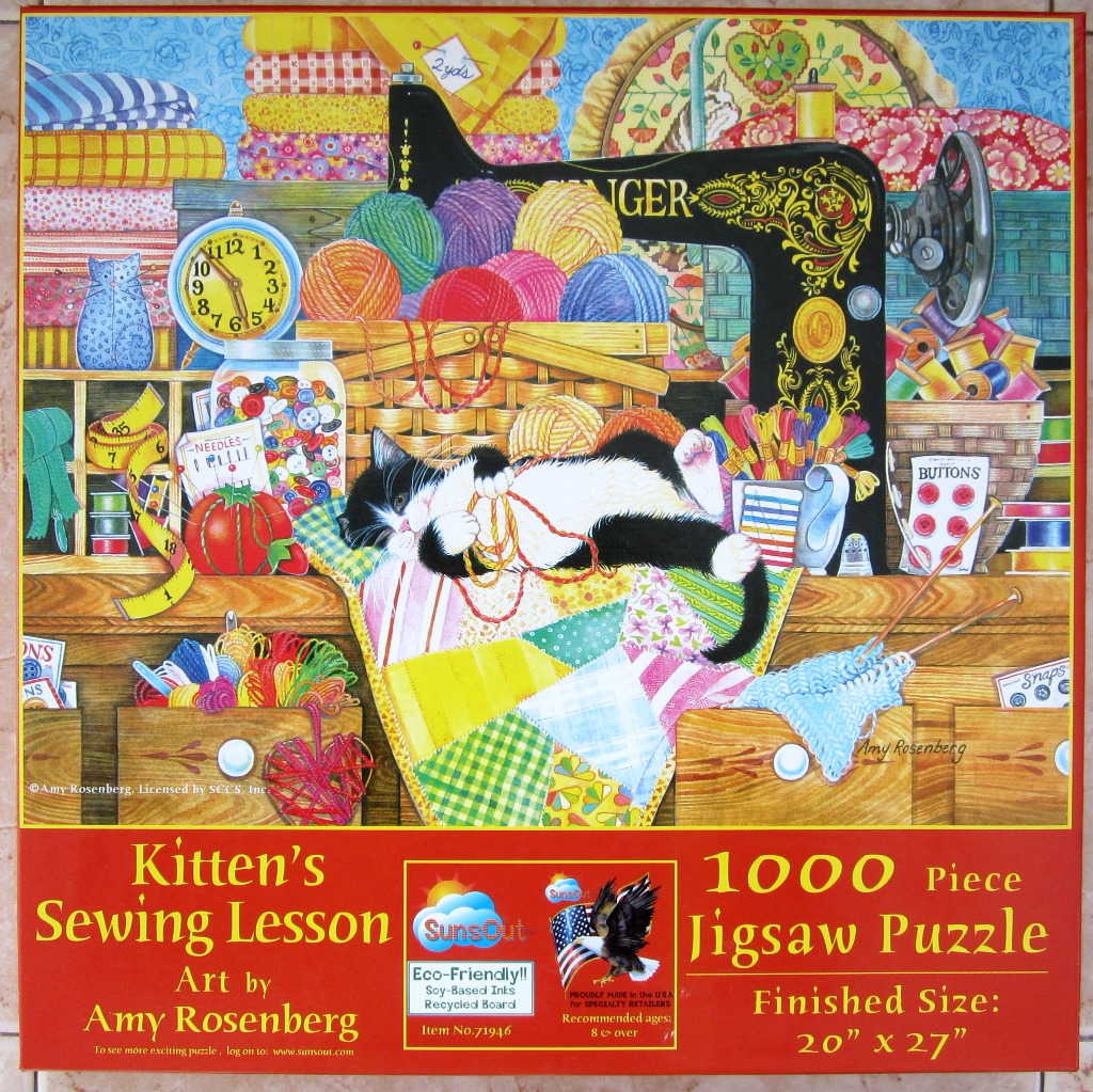 A black and white kitten playing with yarn in a colorful sewing room filled with fabric, notions, and a sewing machine.