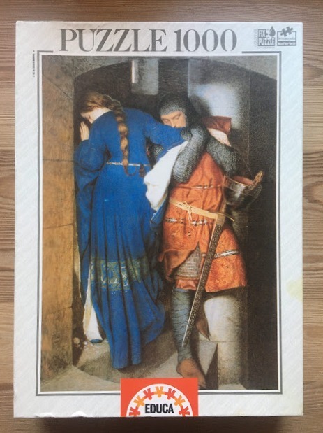 A woman in a long blue dress and a knight in chainmail and a red tunic stand together in a dark stone archway.