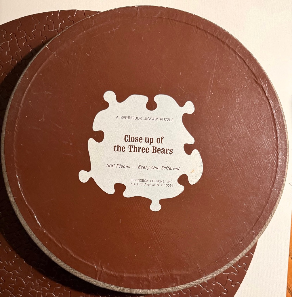 A round brown surface with a white, puzzle-piece shaped central label containing text.