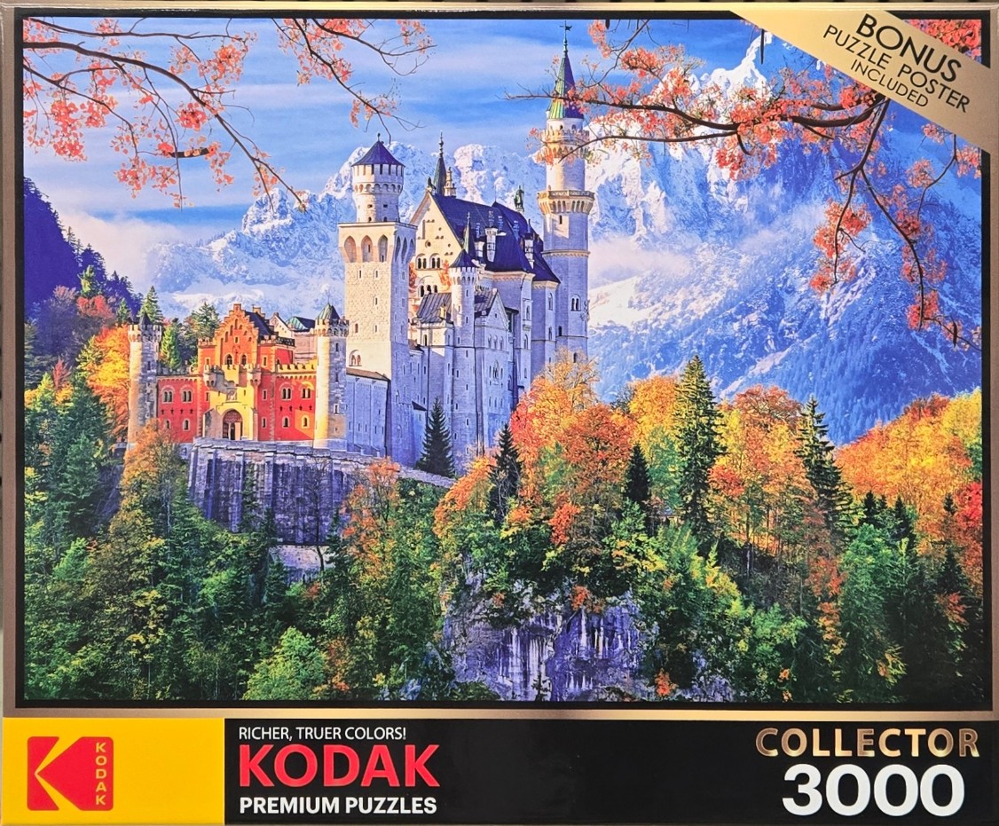 A photograph of Neuschwanstein Castle perched on a cliff amidst autumn forests with snow-capped mountains in the background.