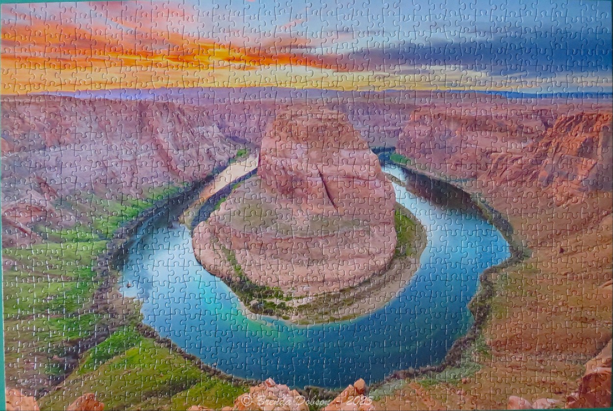 A panoramic landscape of Horseshoe Bend in Arizona at sunset.