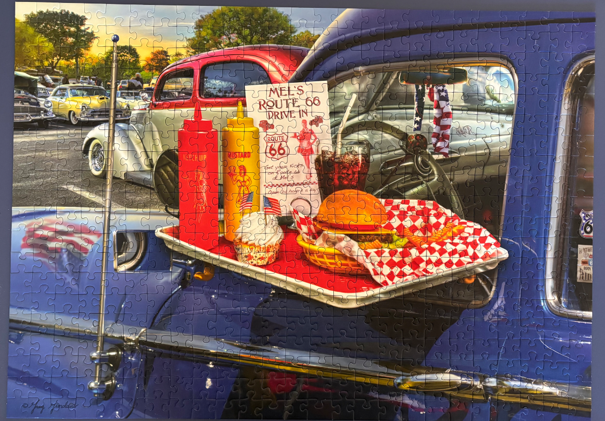 A drive-in restaurant scene featuring a meal on a car window tray with classic cars in the background.
