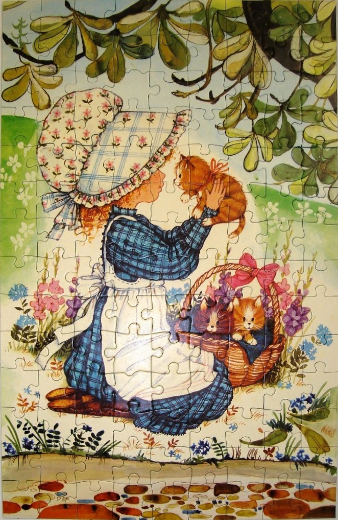 A vintage-style illustration of a girl in a bonnet holding an orange kitten, with another kitten in a basket nearby.