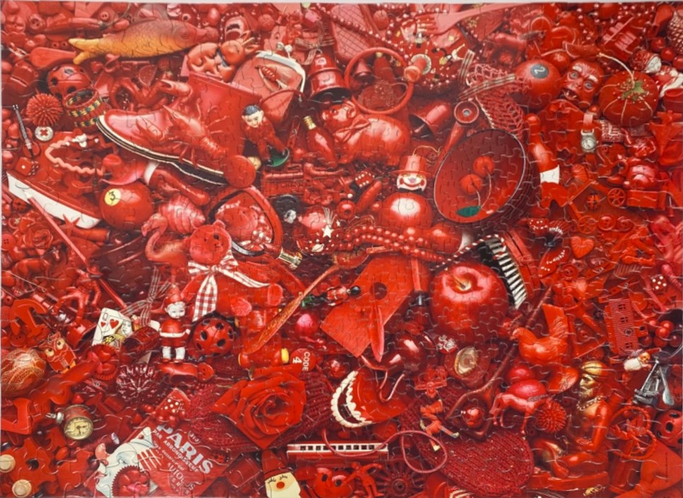 A dense collage of red objects including toys, food, and trinkets.