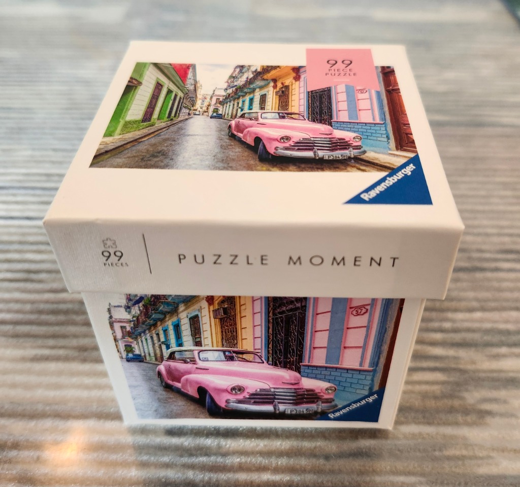 A vintage pink convertible car parked on a narrow, colorful street in Havana, Cuba.