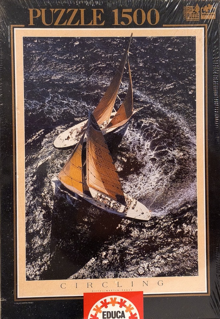 Aerial view of two vintage sailing yachts with tan sails maneuvering in deep blue, choppy water.