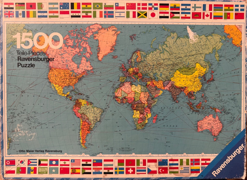 A vintage political world map surrounded by a border of various international flags.