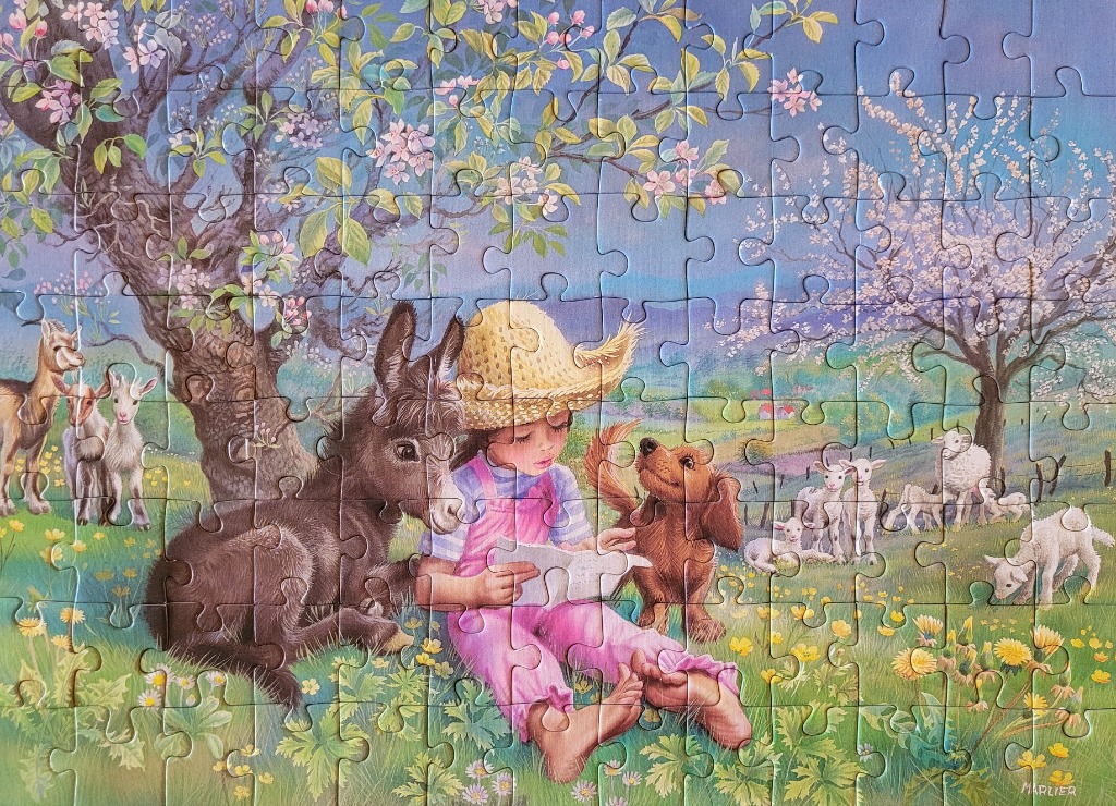 A young girl in a straw hat sitting in a meadow with a donkey and a puppy, surrounded by baby goats and sheep.