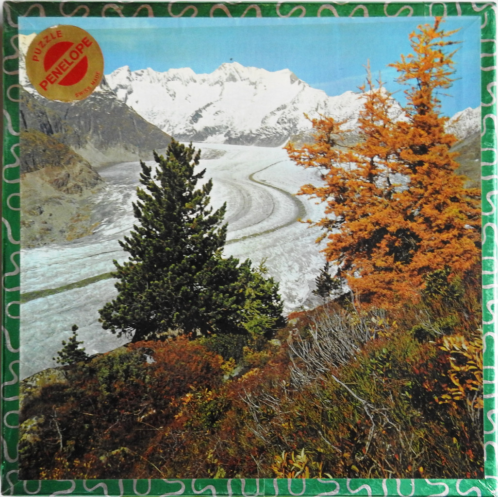 A photograph of a sweeping Alpine glacier flanked by autumn-colored larches and evergreen trees under a bright blue sky.