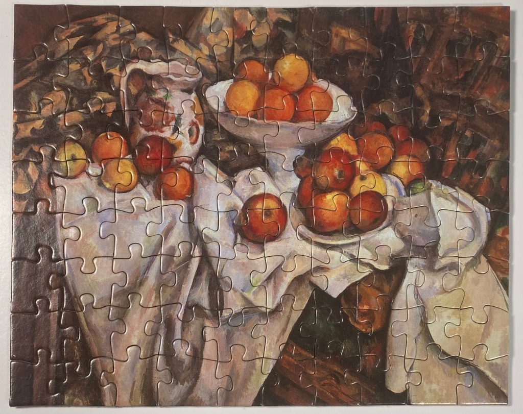 Still life oil painting featuring a white pitcher and bowls filled with red and orange apples on a draped white cloth.