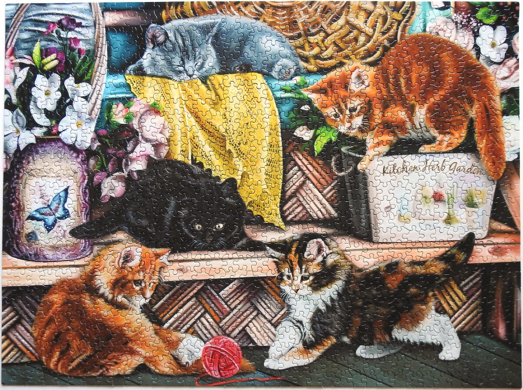 Five kittens lounging and playing in a cozy garden setting with flowers, baskets, and a ball of yarn.