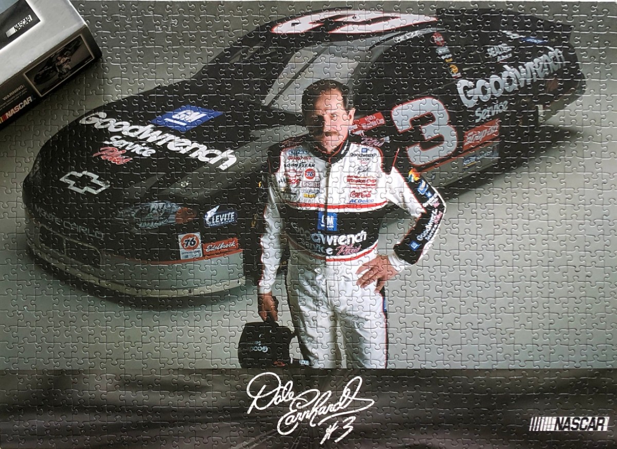 Dale Earnhardt Sr. standing in front of his black number 3 race car.