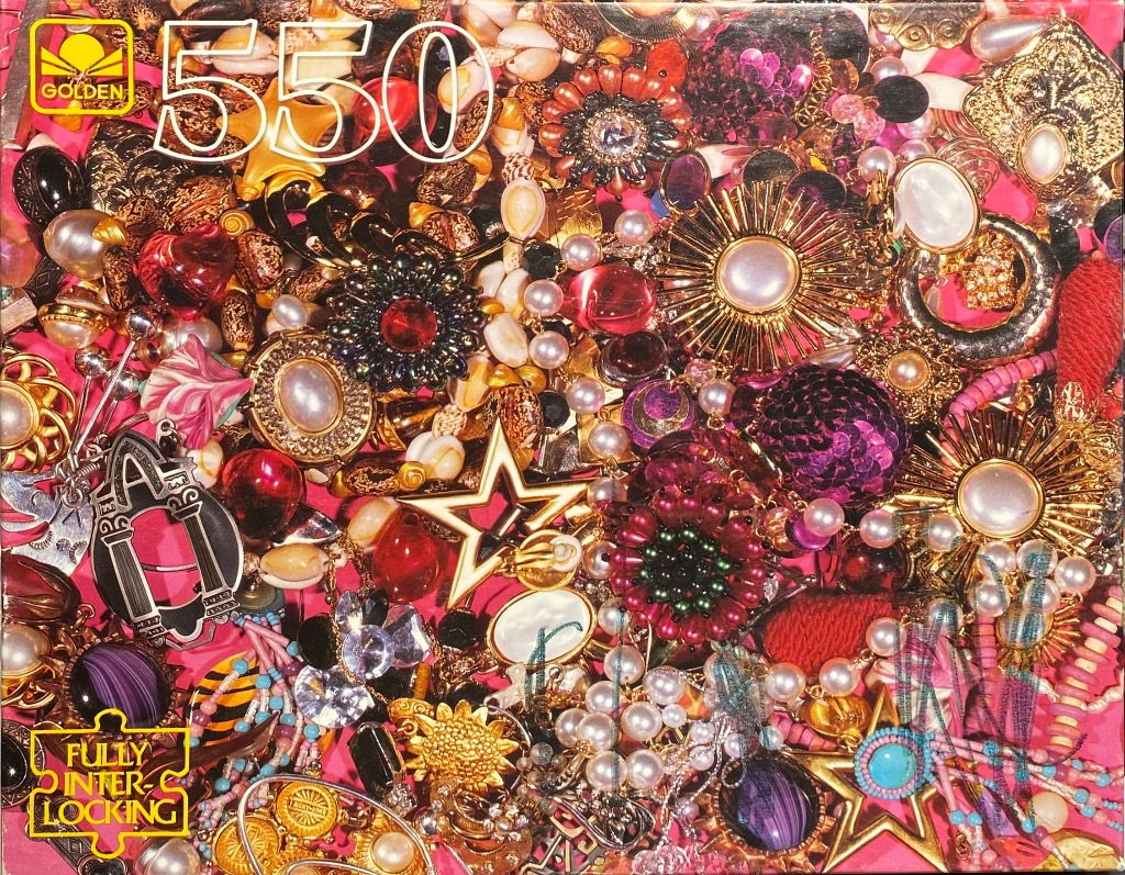 A dense, colorful collection of costume jewelry, beads, and vintage accessories scattered over a bright pink background.