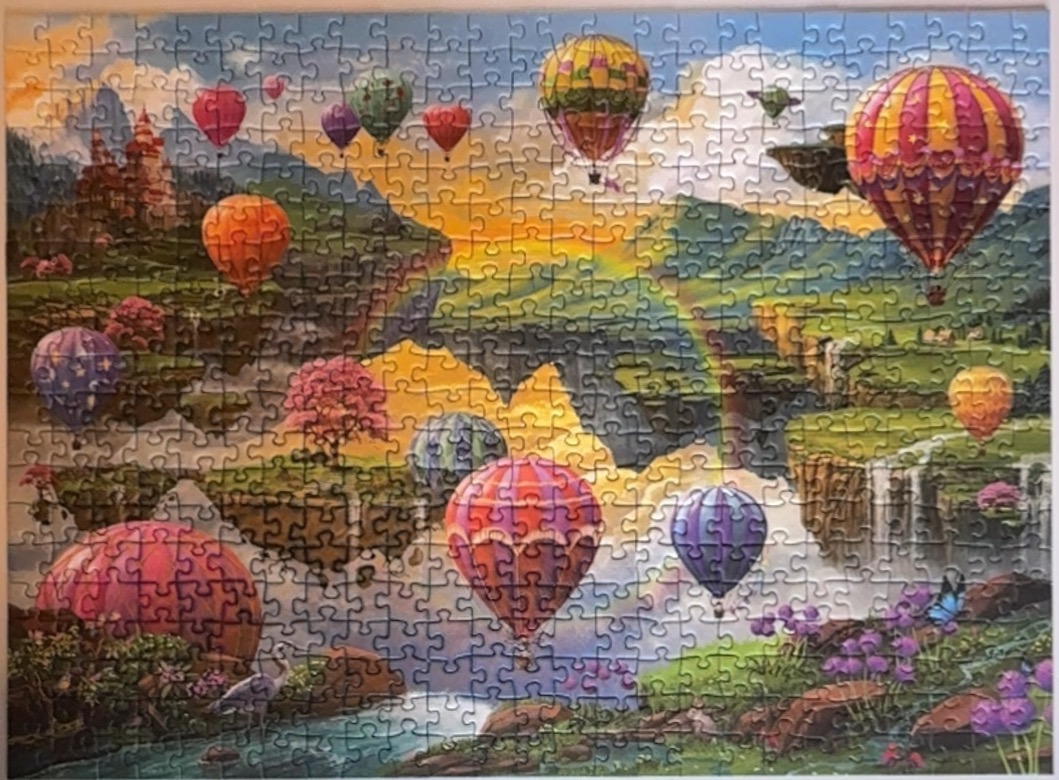 Fantasy landscape with hot air balloons floating over floating islands, a waterfall, and a castle.