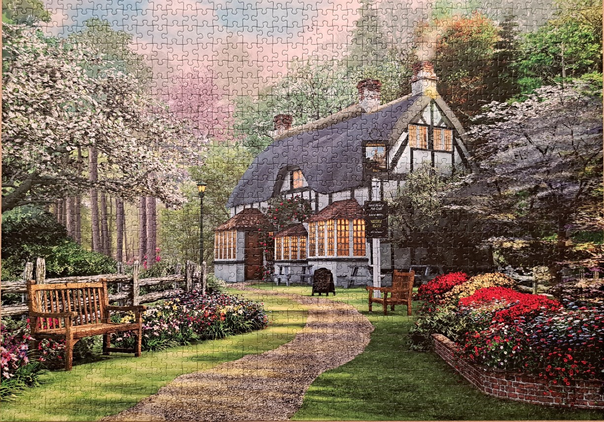 An idyllic English cottage pub surrounded by blooming spring gardens and trees.