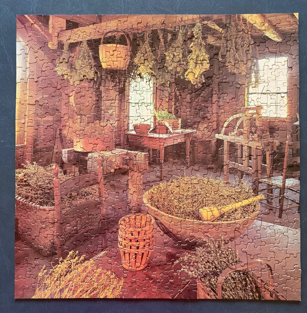 Rustic wooden interior of a country workshop filled with dried herbs, baskets, and spinning wheels.