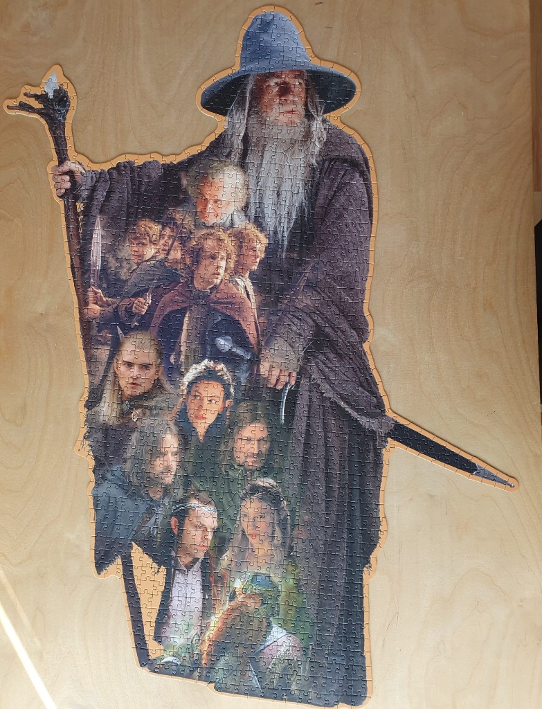 A shaped collage of characters from The Lord of the Rings, dominated by a large figure of Gandalf.