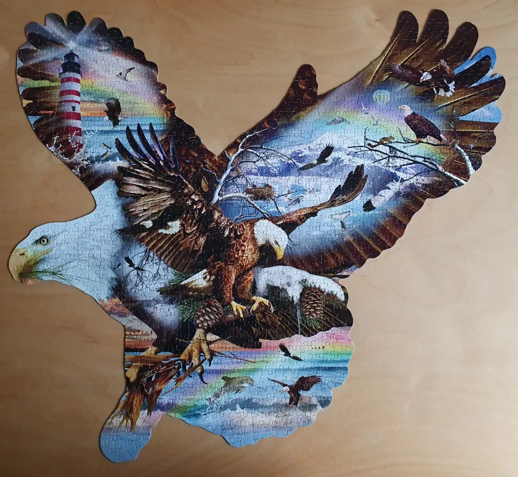 A shaped image of a bald eagle in flight, containing a scenic collage of nature and a lighthouse.