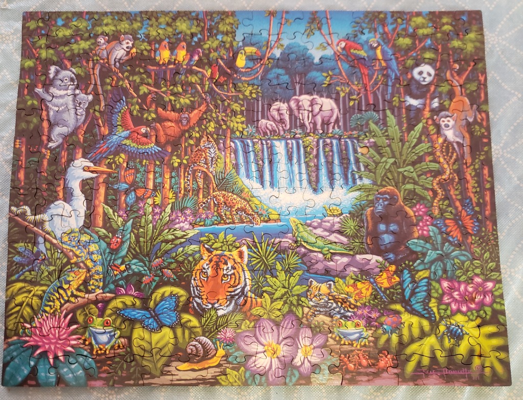 A lush jungle scene filled with diverse wildlife, including a tiger, gorilla, and waterfall.