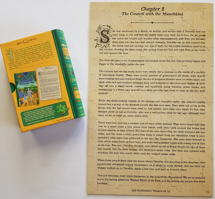 A rectangular page from The Wonderful Wizard of Oz, titled Chapter 2, alongside its green and yellow book-themed box.